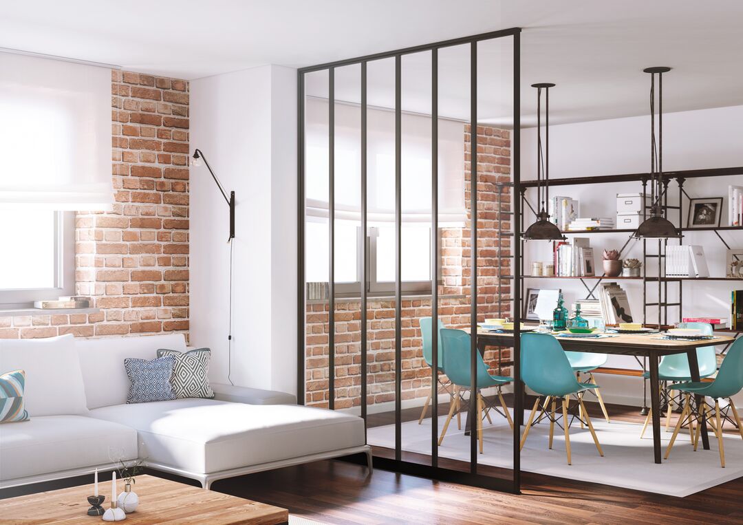 Loft avec murs en briques et verrière industrielle