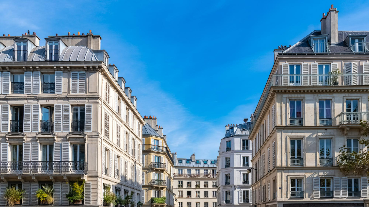 Façade d’un immeuble haussmannien typique avec plusieurs appartements.